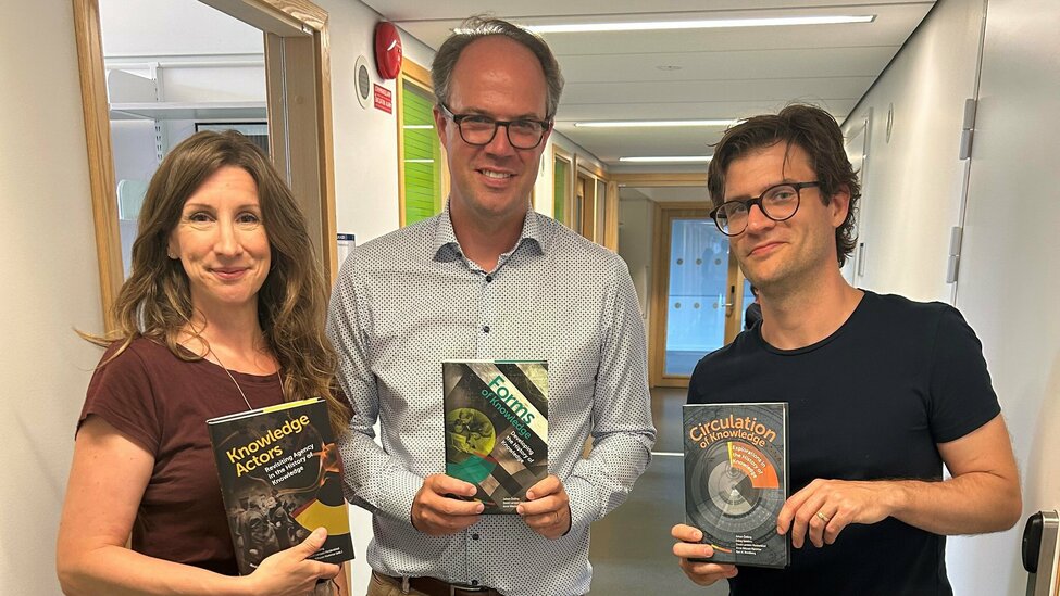 Anna, Johan och David håller upp boken